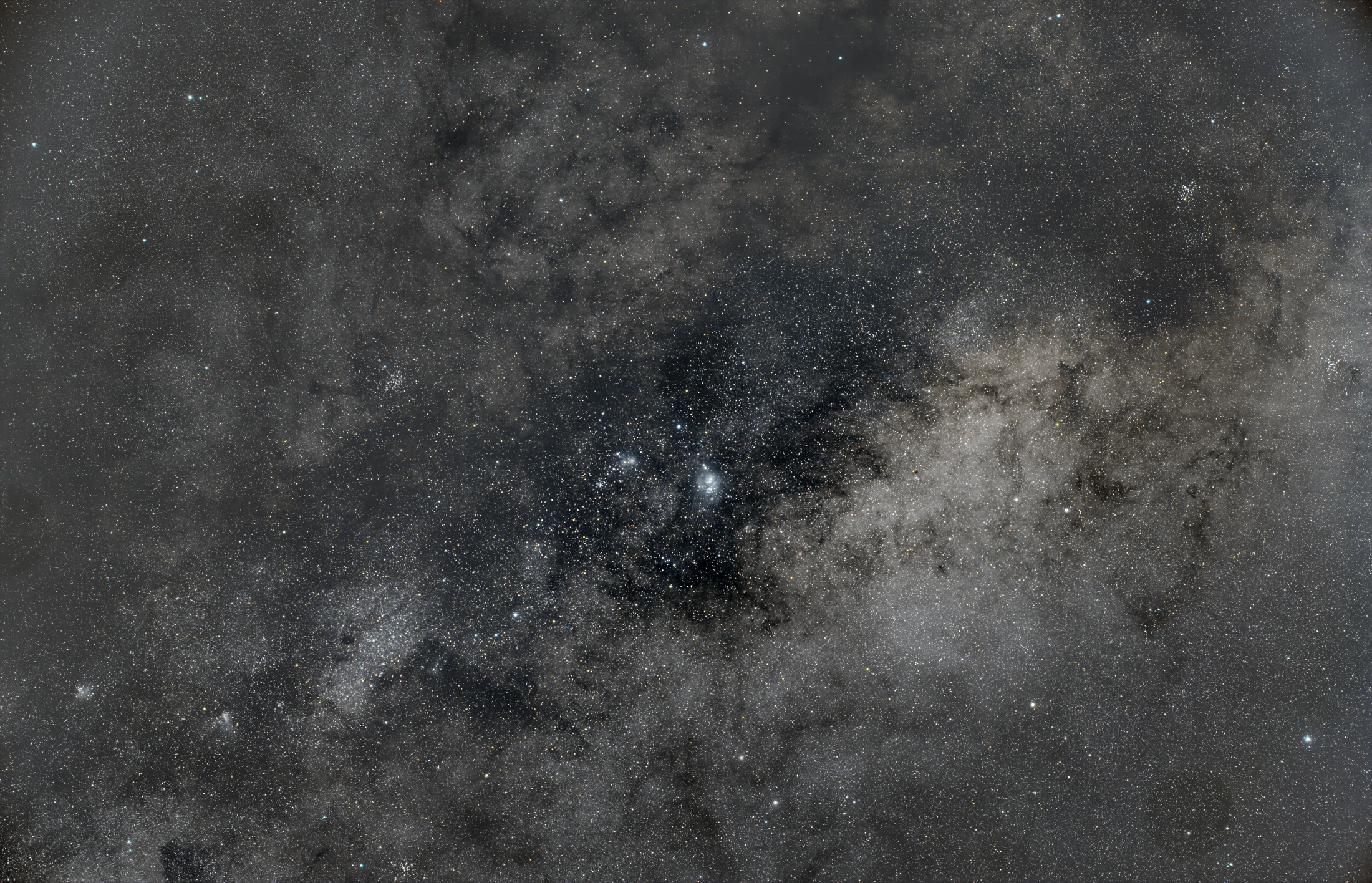 A wide field of stars and dark dust around the bright Lagoon Nebula